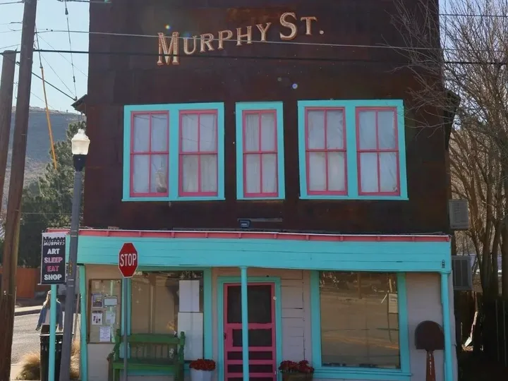 The Murphy St. storefront, a two-story building with turquoise and pink trim.