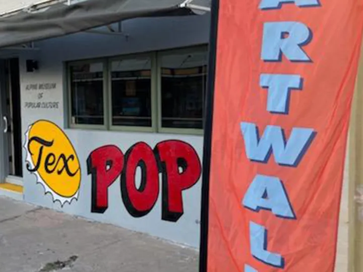 The TexPop storefront with its bottle-cap sign, beside an orange Artwalk flag.